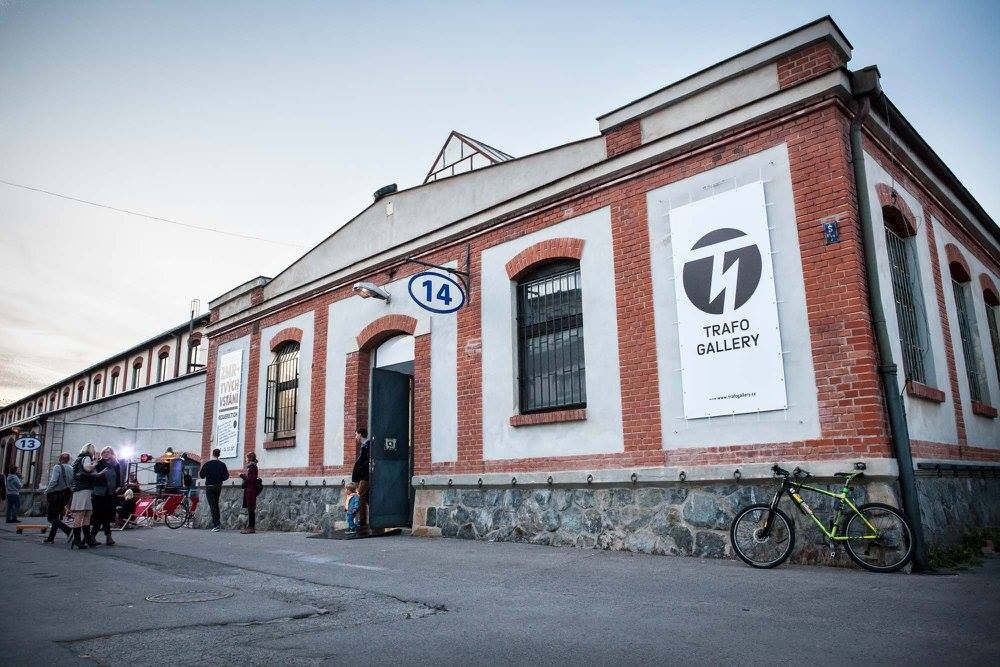 Un bâtiment en briques rouges et blanches, avec des personnes devant