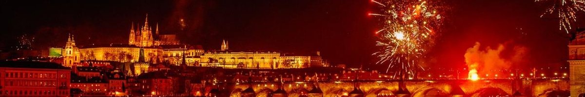 Ville de Prague sous les feux d'artifice en rouge avec le fleuve qui passe en dessous du pont