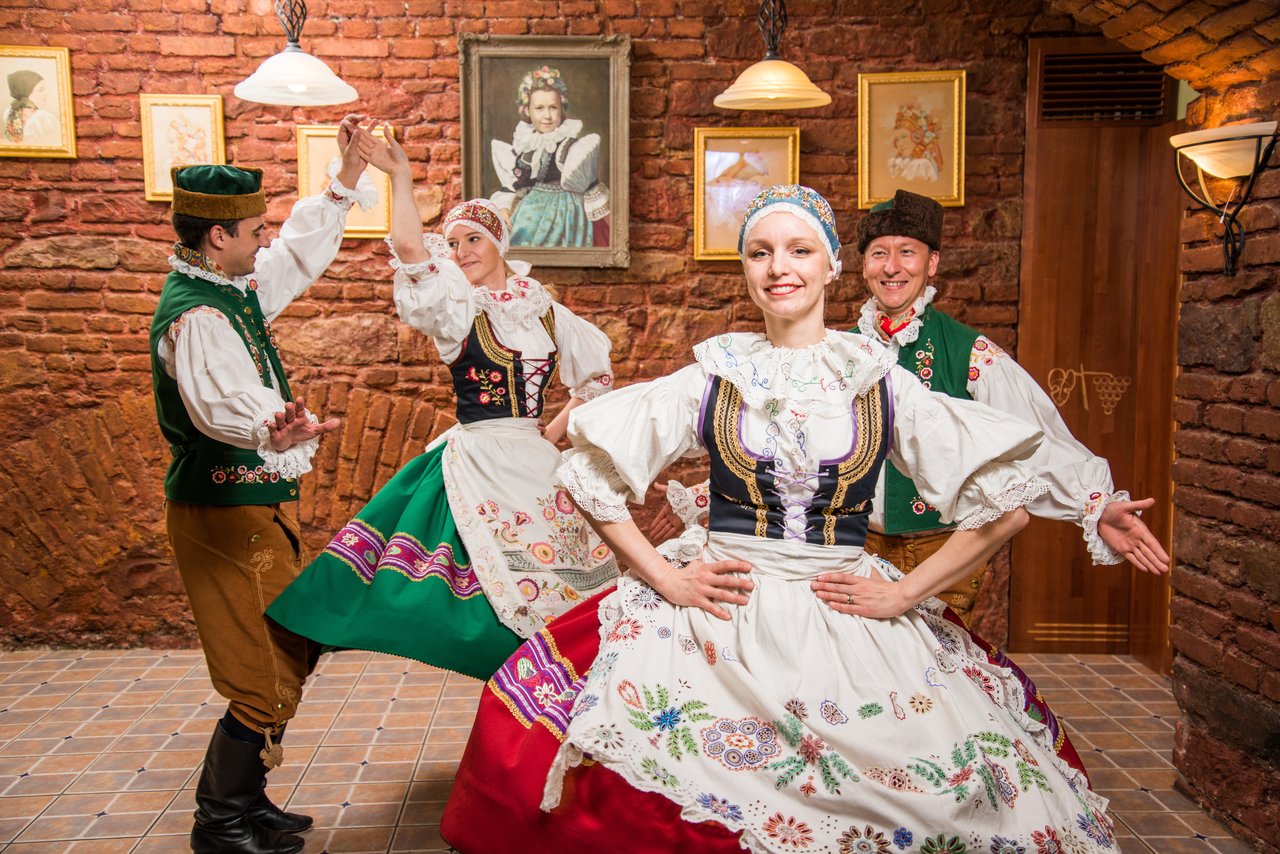 Deux femmes et deux hommes qui font une danse traditionnelle en tenue colorée avec des motifs à fleurs