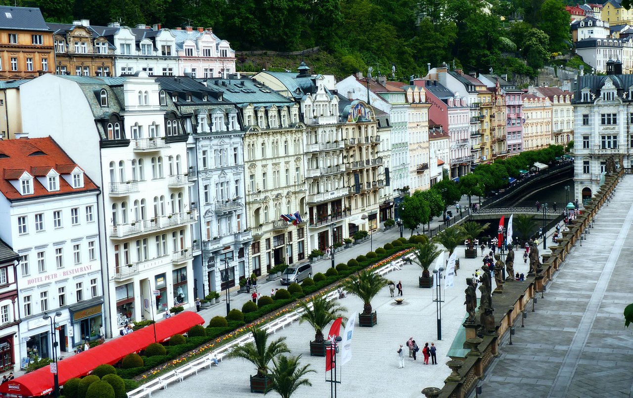 De grands bâtiments historiques aux détails raffinés et aux façades colorées bordent une large rue piétonne