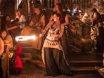 en:A woman in medieval costume dancing with a large burning ship—the audience is surprised; fr:Femme en tenue médiévale qui danse avec un grand bateau enflammé, le public est surpris
