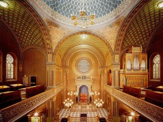 en:A majestic hall with walls carved in gold featuring Hispano-Moorish motifs, and circular stained-glass windows with designs ;fr:Salle majestueuse aux murs sculptés d'or avec des motifs hispano-mauresque, les vitraux circulaire avec des motifs
