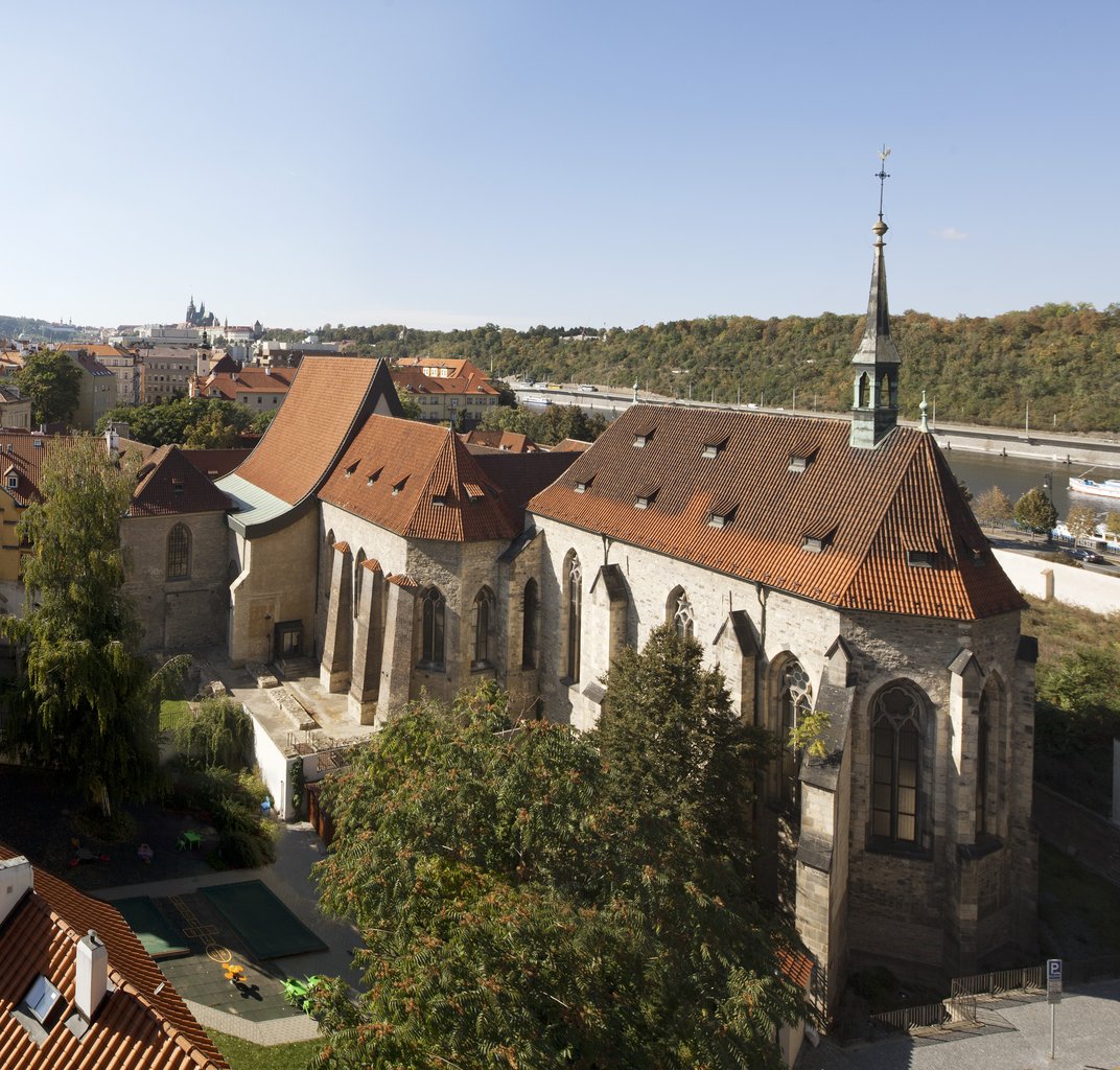 Grand bâtiment en pierre avec de grands vitraux et un toit pointu rouge