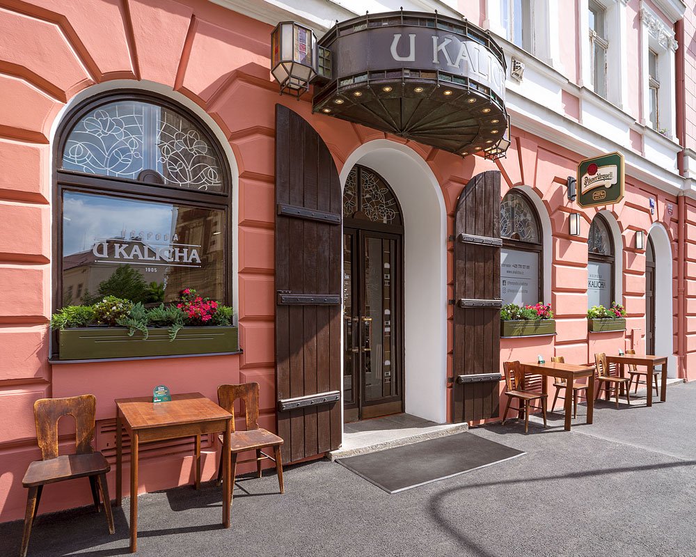 Façade rose de la brasserie avec une grande porte en bois