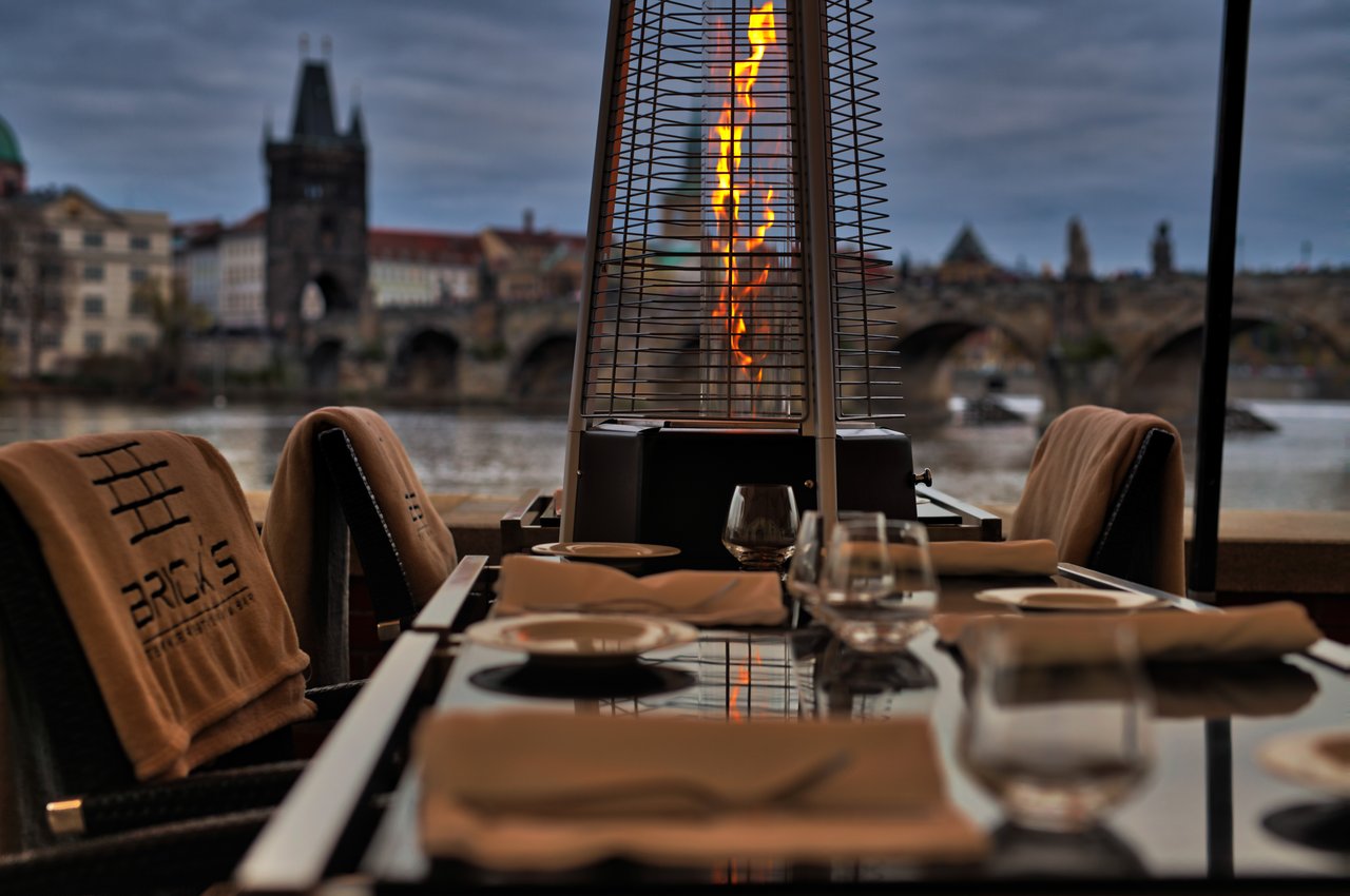 Petit brasier à côté d'une table en extérieur, on peut apercevoir la ville en arrière