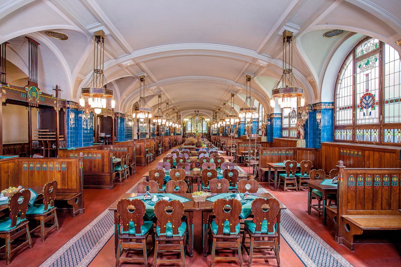 Intérieur d'une brasserie avec beaucoup de tables et beaucoup de couleur, avec un plafond voûtée