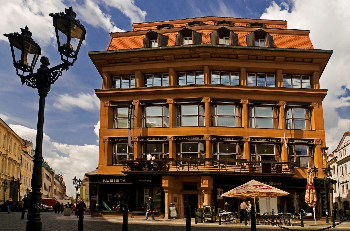 Maison de style cubiste avec une façade orange, exposée à la lumière du soleil pendant la journée.