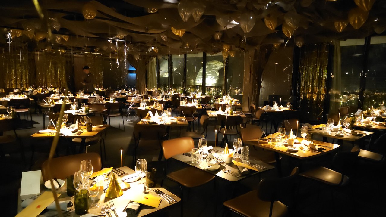 Grande salle de restaurant avec beaucoup de tables et il y a des décorations avec des ballons