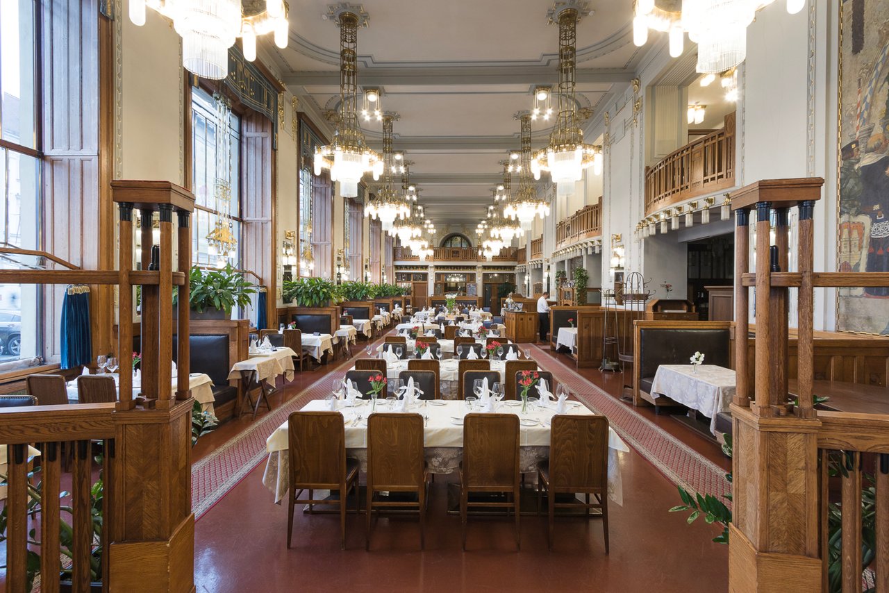 Une grande rangée de tables avec des lustres éclairée accroché au plafond