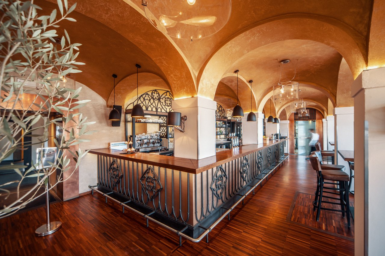 Bar dans un restaurant avec un plafond voûtée et des piliers blancs