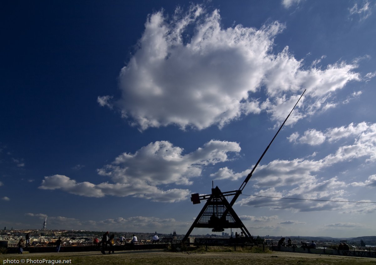 Un très grand métronome avec un ciel bleu et quelques nuages