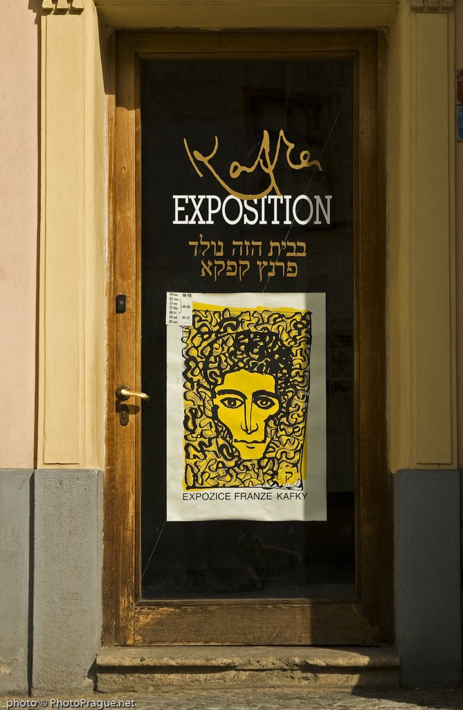 Une porte en bois vitrée avec une grande affiche rectangulaire jaune et noire représentant un visage