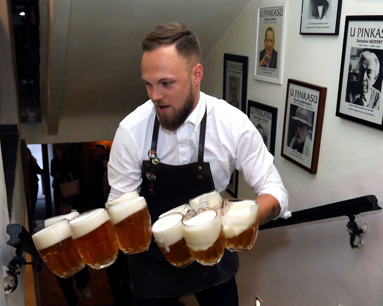 Serveur qui porte plusieurs verres de bière dans c'est deux mains