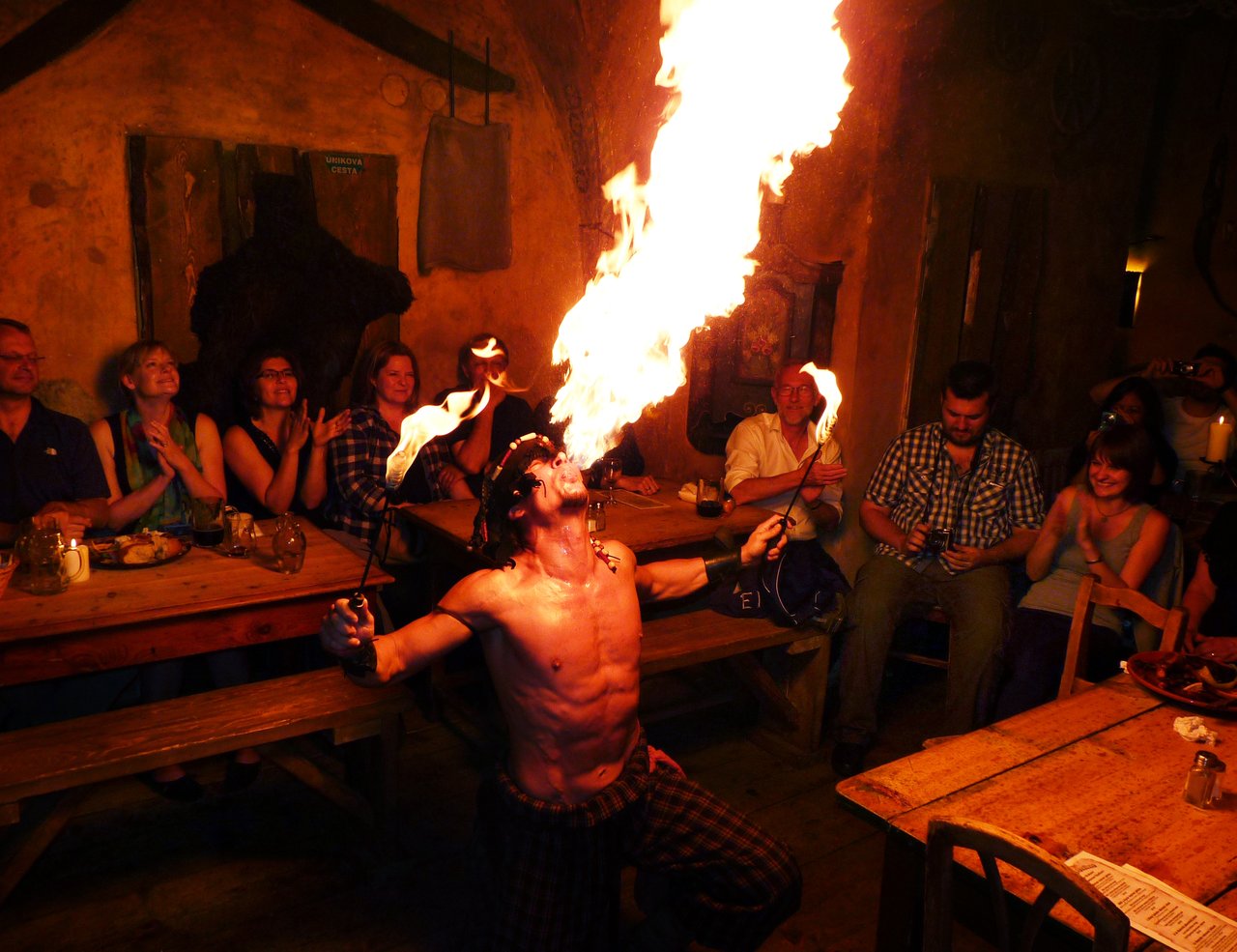 Un cracheur de feu lance une grande flamme, le public applaudit