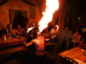 en:A fire-eater shoots out a huge flame; the audience applauds; fr:Un cracheur de feu lance une grande flamme, le public applaudit