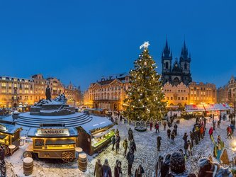 en:A large Christmas market with a big decorated Christmas tree in the center; night is falling and the city is lit up; fr:Un grand marché de Noël avec un immense sapin décoré en son centre, la nuit tombe et la ville s'illumine
