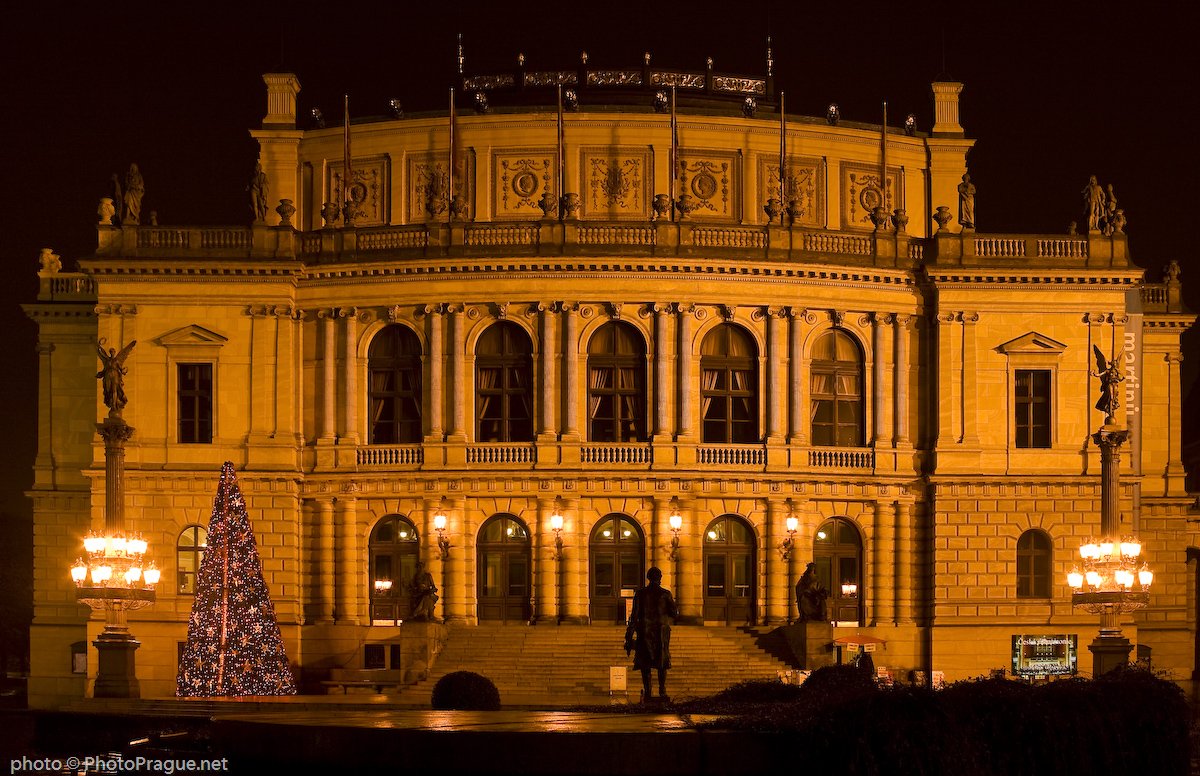 Grand monument avec deux étages de cinq fenêtres avec un sapin juste à gauche