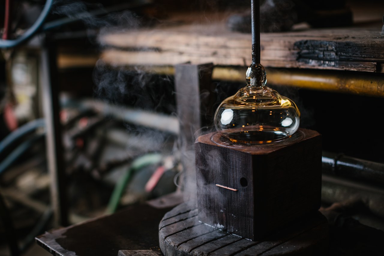 Une forme de verre qui fume avec un outils en bois obtenir la forme désirée